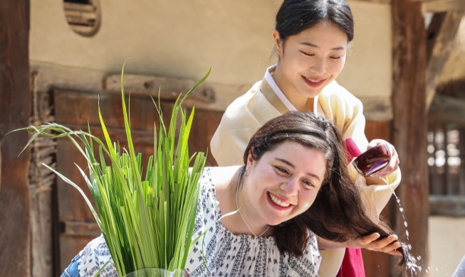 Washing hair in water mixed with sweet iris leaves