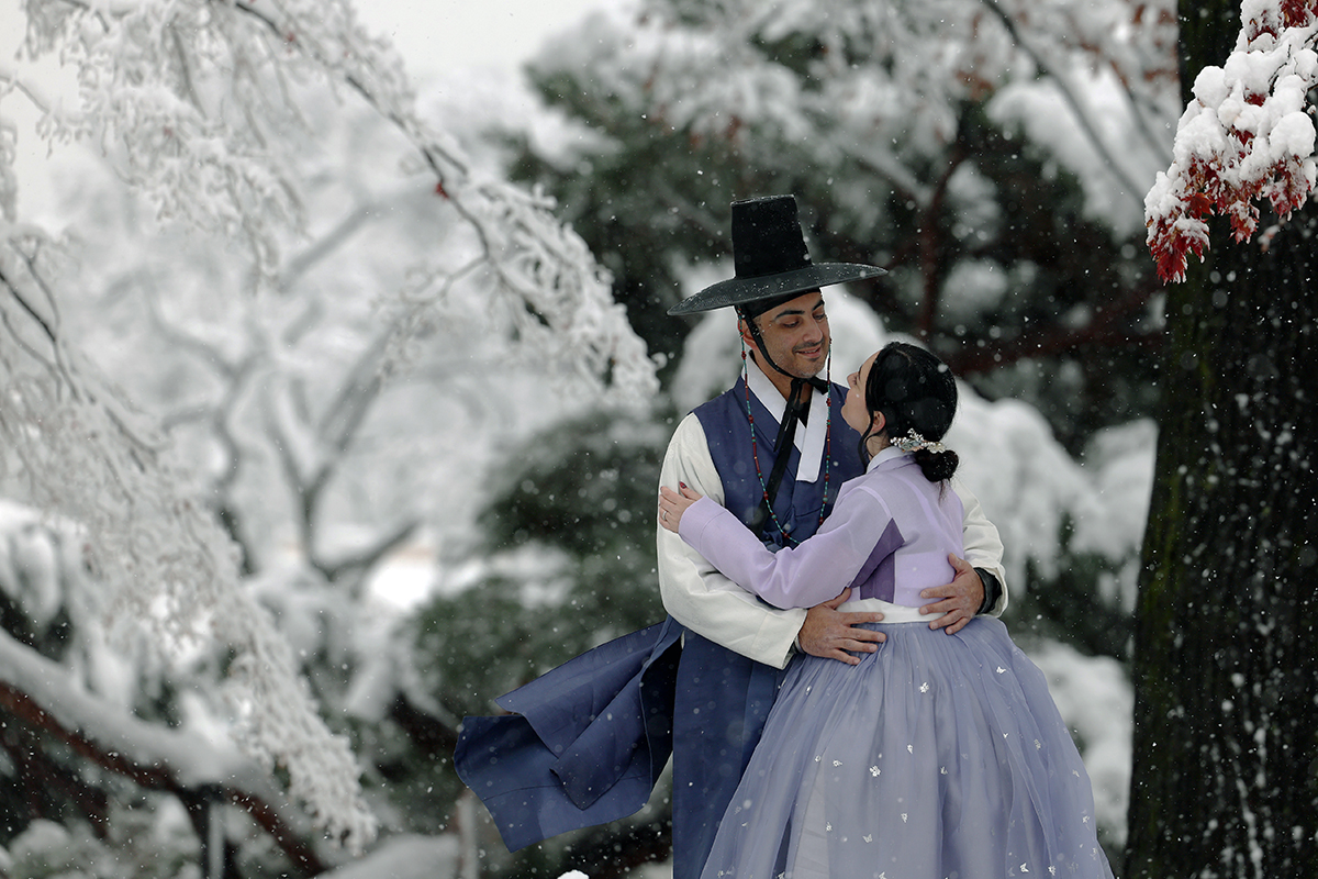 A foreign couple wearing Hanbok on the morning of Nov. 27 pose for a photo against a snowy backdrop at Gyeongbokgung Palace in Seoul's Jongno-gu District.