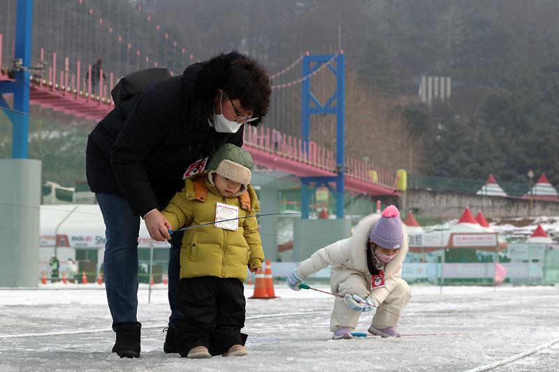 Two children on Jan. 14 fish for sancheoneo (mountain trout) at the Hwacheon Sancheoneo Ice Festival in Hwacheon-gun County, Gangwon-do Province.