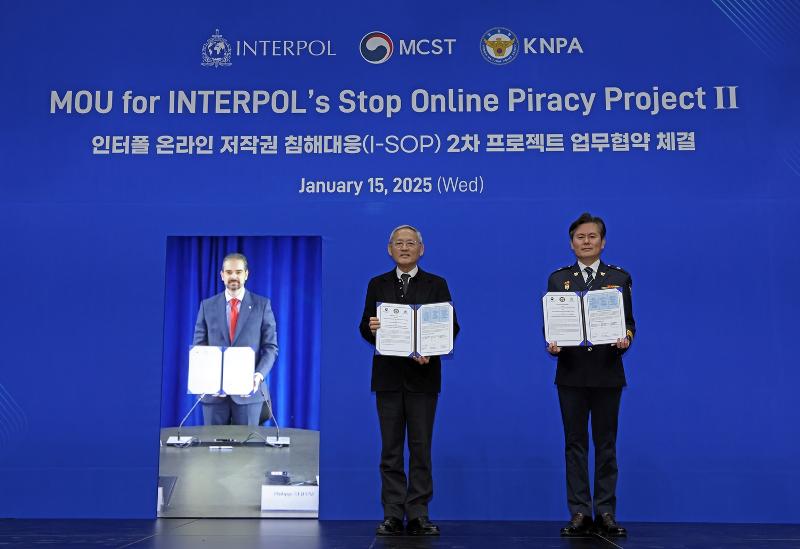 Minister of Culture, Sports and Tourism Yu In Chon (center) on Jan. 15 poses for a photo at the signing ceremony for a memorandum of understanding on Interpol's Stop Online Piracy Project II at the National Museum of Modern and Contemporary Art, Korea in Seoul's Jongno-gu District. From left are a large photo of Interpol Secretary-General Valdecy Urquiza, Minister Yu and Lee Jun-hyeong, director-general of the Korea National Policy Agency's International Cooperation Bureau. (Ministry of Culture, Sports and Tourism)  